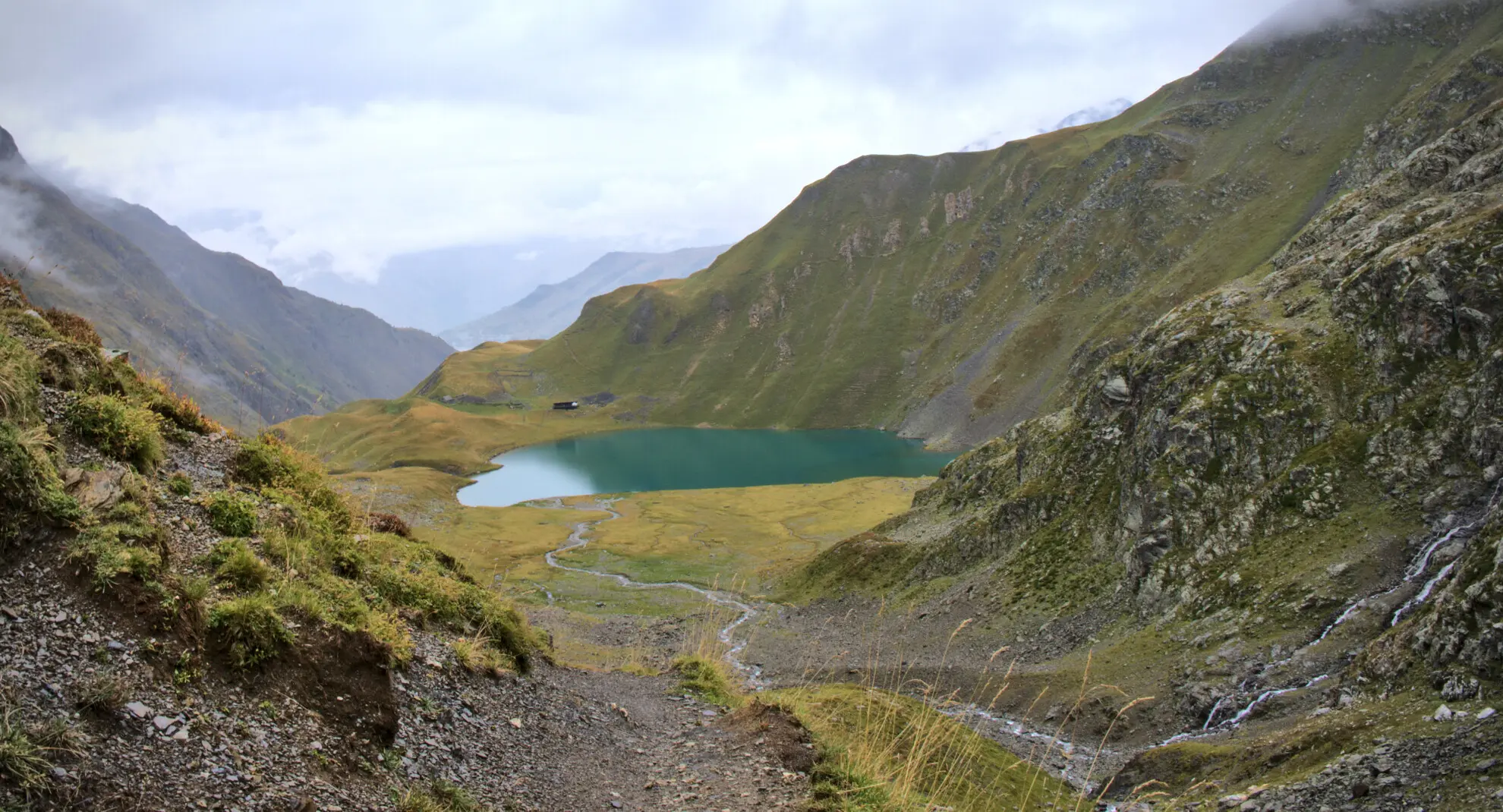 Le lac de la Muzelle vu depuis le sentier de descente, avec le refuge au bord de l'eau